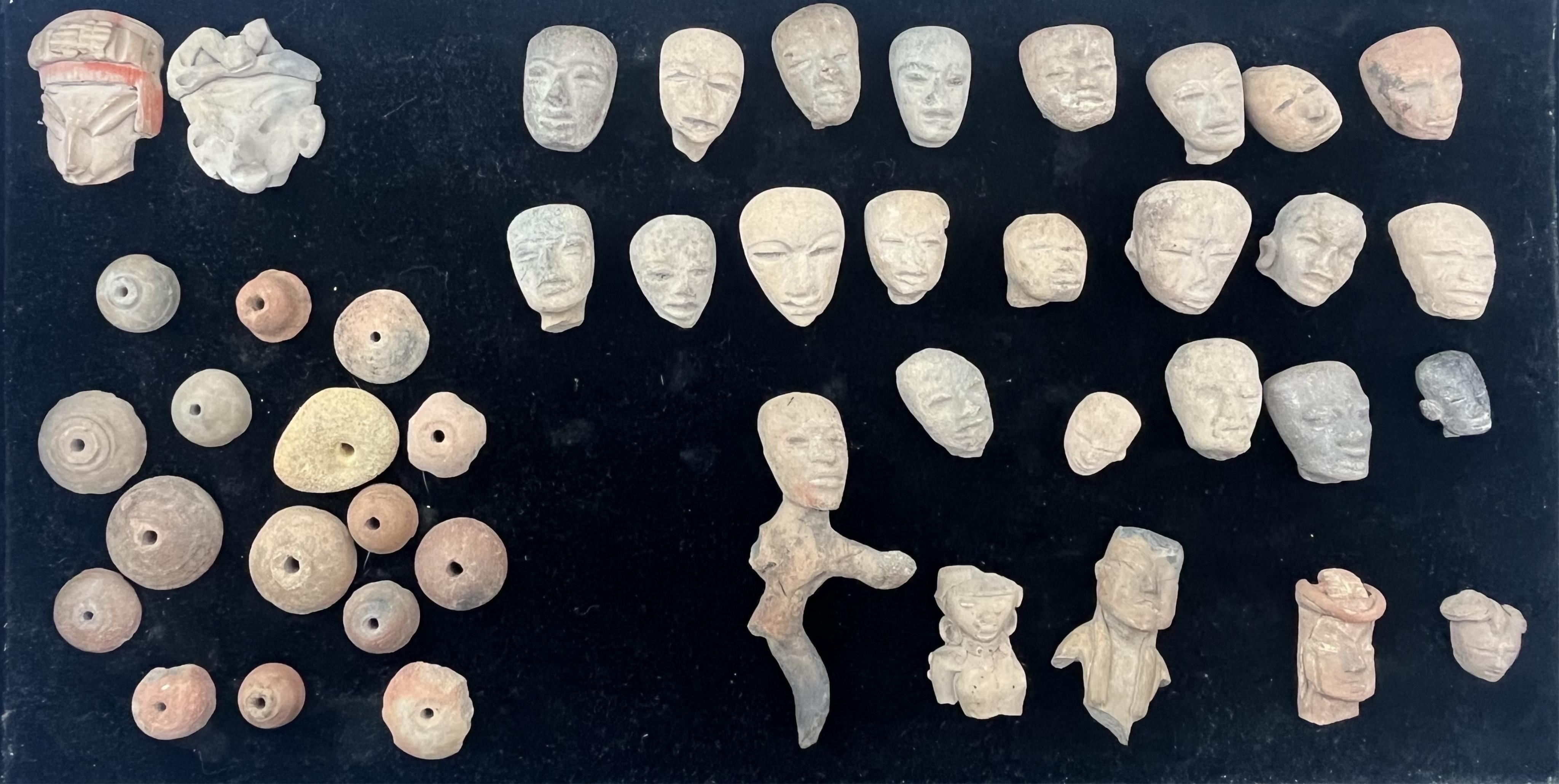A group of pre-Colombian terracotta heads, a partial figure and beads, Mexico